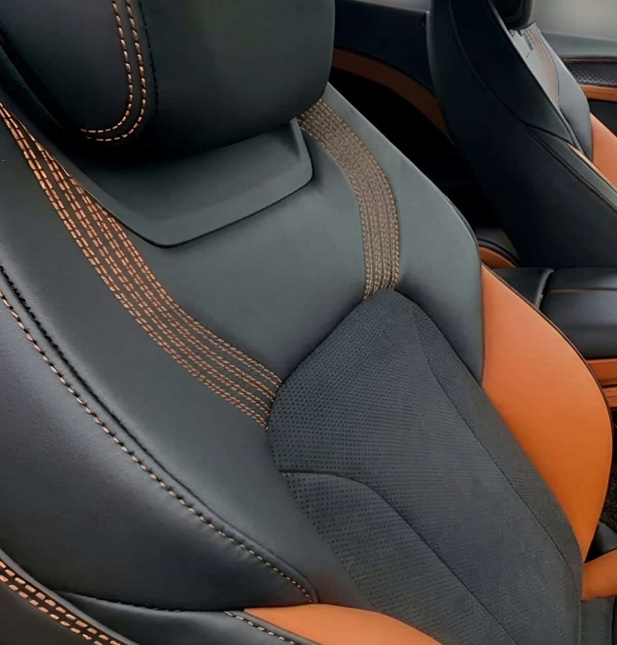 Bronze contrast stitching across dark leather, close enough to count the threads.