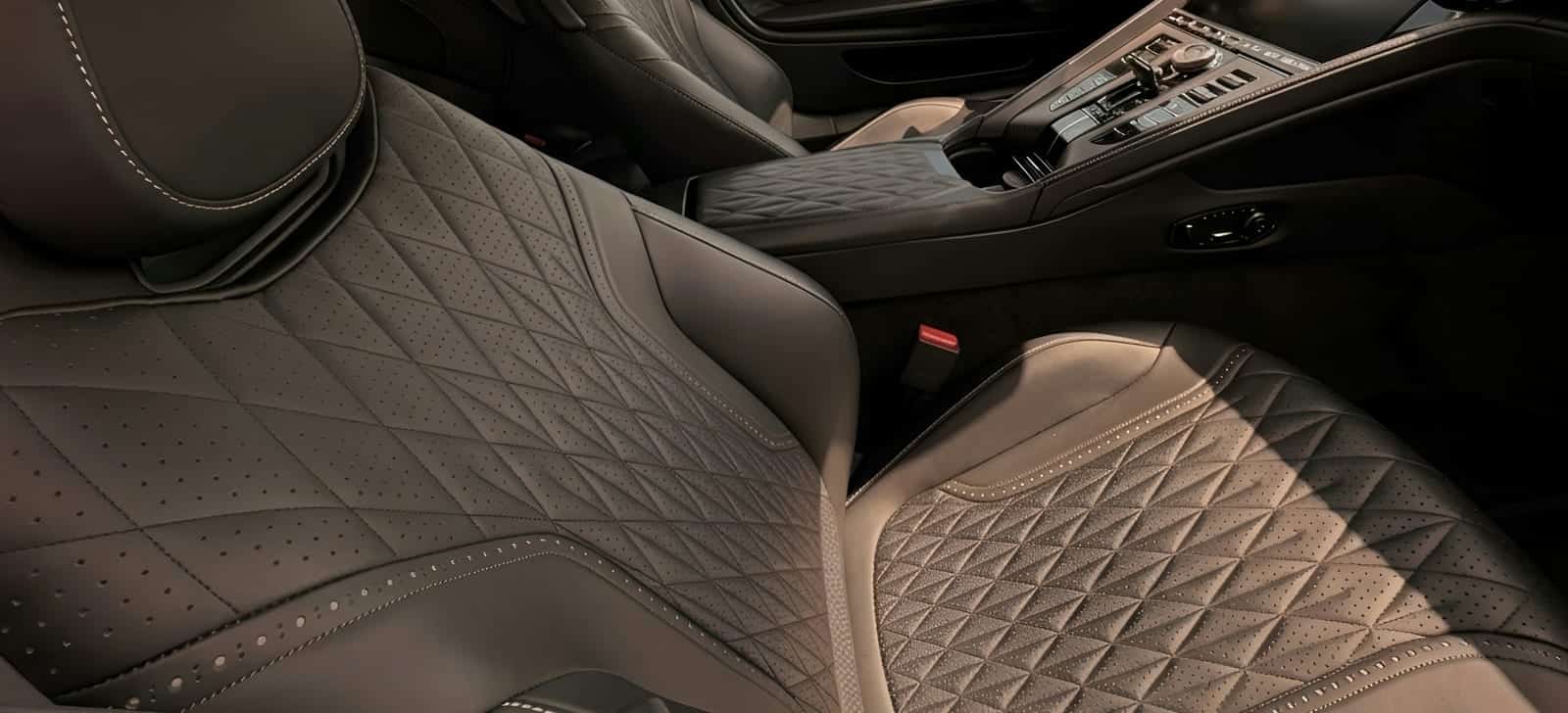 Diamond-quilted seats under raking light after restoration.