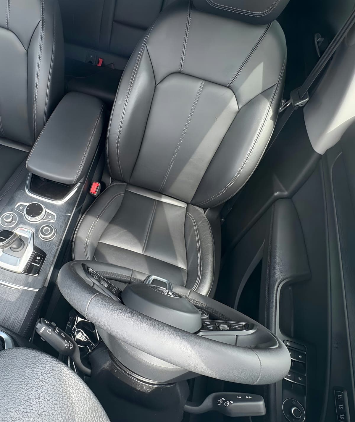 A gray working cabin's driver seat, cleaned back to neutral.